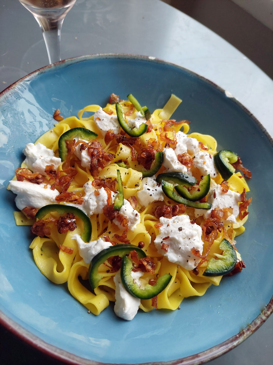 A serving of saffron tagliatelle in a blue dish