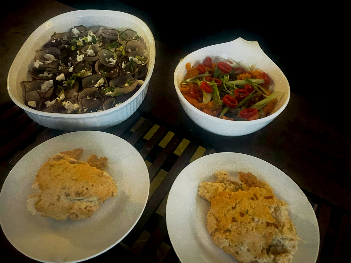 Four dishes of food on a dark wooden table