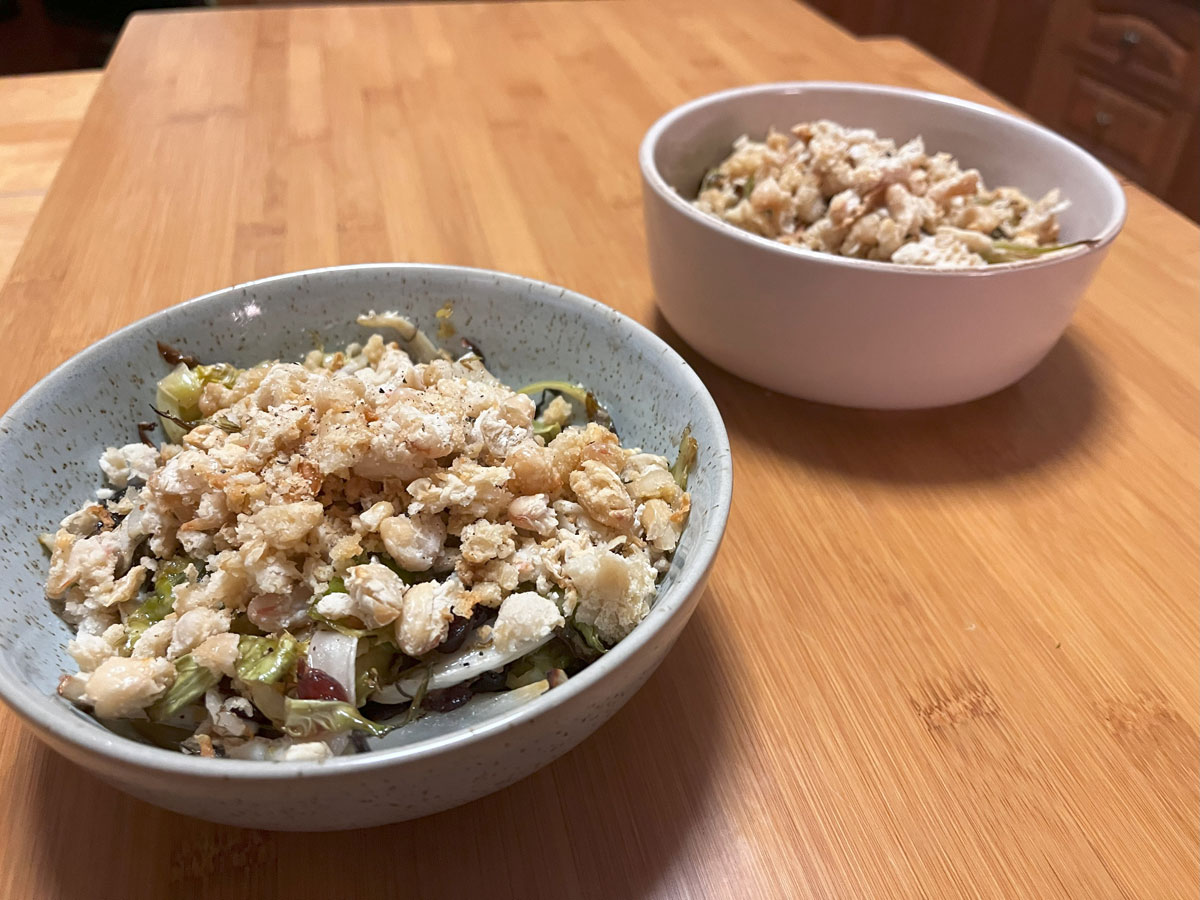 baked salad in 2 bowls with baked blitzed white beans sprinkled on top