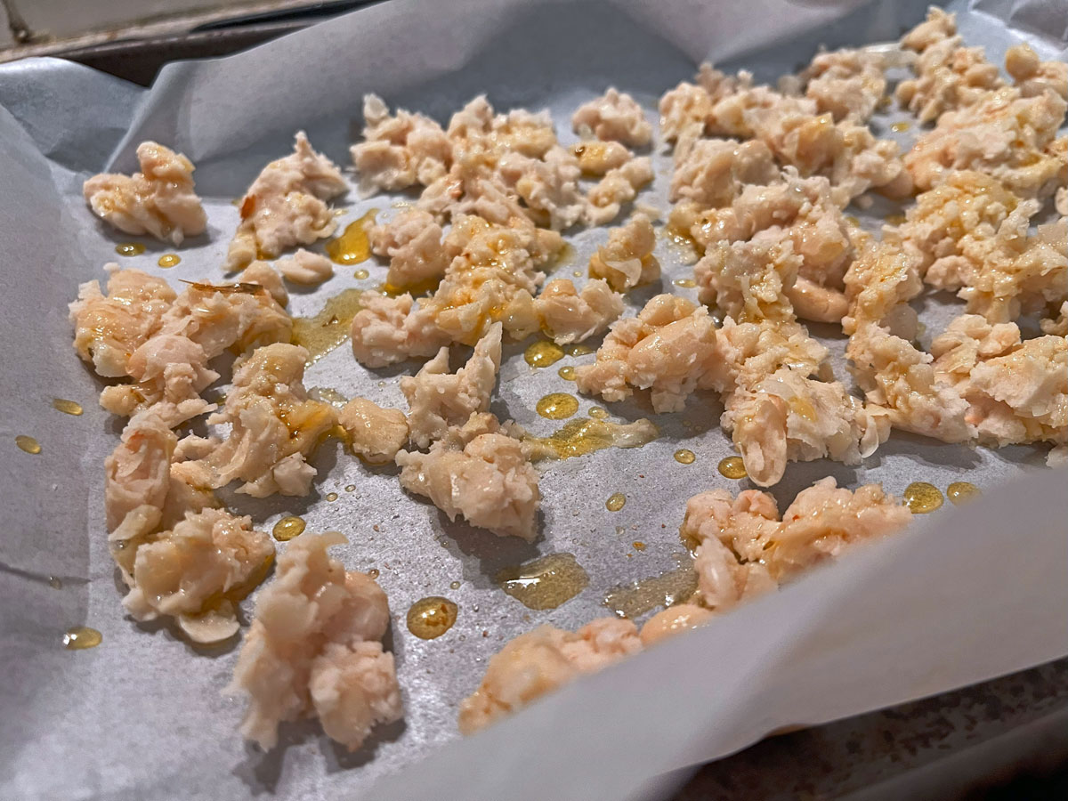 blitzed white beans spread out across a tray, drizzled with olive oil and seasoned with salt and pepper